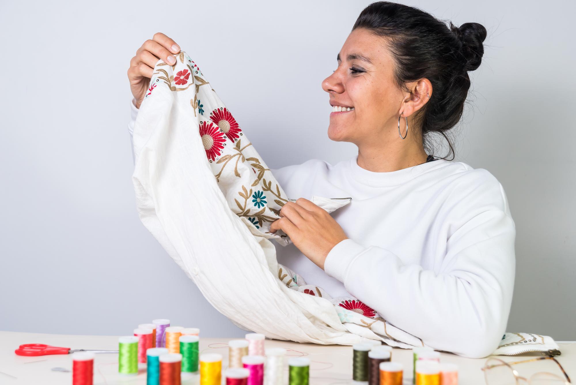 Artist holding embroidered textile in studio light