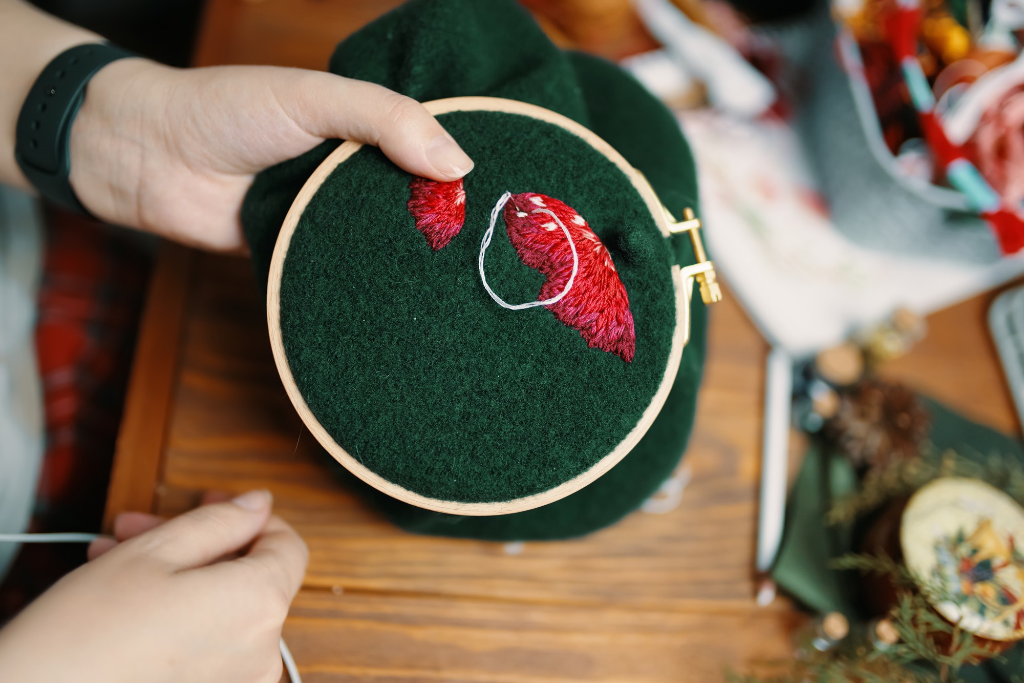 Workshop hands adjusting hoop with embroidery